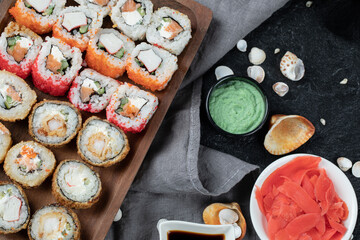 Hot sushi set on a wooden board with mixed ingredients
