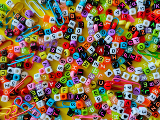 Obraz na płótnie Canvas Selective focus of colorful word dice on a yellow background.Shot were noise and film grain.