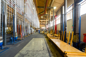 Fototapeta premium Metal parts are suspended on an overhead conveyor. Line painting in an electrostatic field