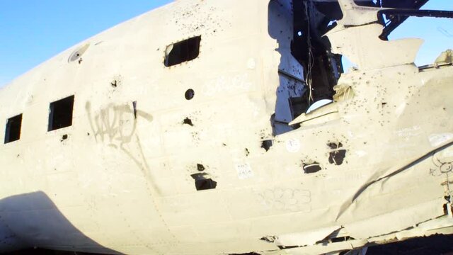 Crashed plane wreckage on black sand beach in Iceland. Gimbal shot in 50fps slowly pulling back.