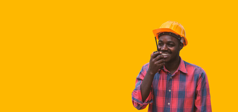 African American engineer use walkie talkie to communicate with yellow backgrounds - Powered by Adobe