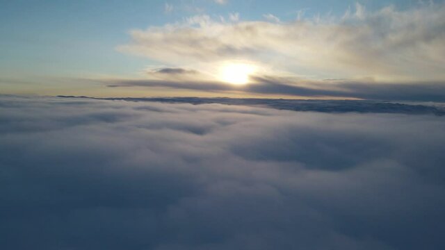 Drone footage above the clouds in winter at sunset time. Southern Norway