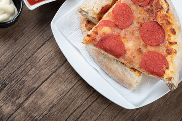 Pepperoni pizza slices in a white ceramic plate