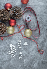 Happy new year writing with christmas cones and balls around 