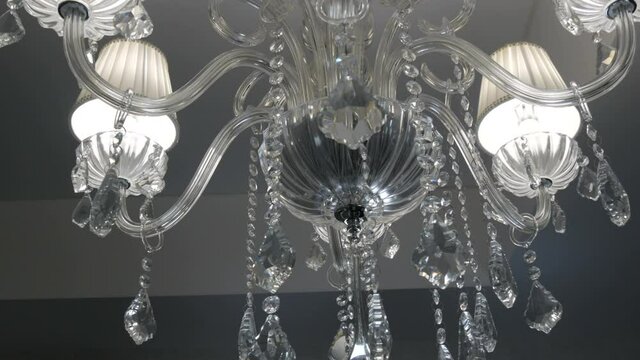 Beautiful luxury chic crystal chandelier on the ceiling in a stylish modern room.