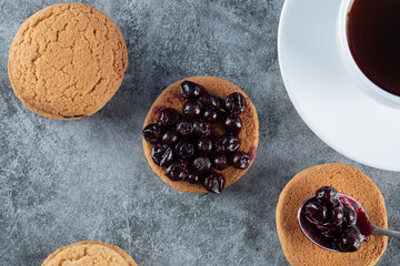 Oatmeal cookies with blackcurrant berries confiture served with a cup of tea