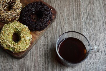 Doughnuts and long black coffee on the wooden table