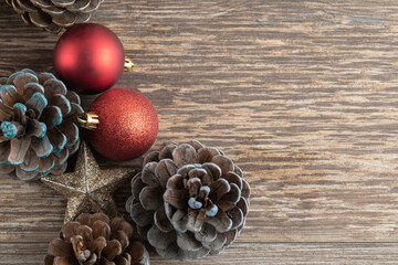 Natural oak tree cones on a wooden deck with glittering ornaments around