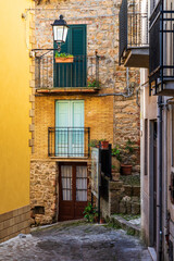 Fototapeta na wymiar Italy, Sicily, Palermo Province, Pollina. Balconies above a cobblestone city street in Pollina.