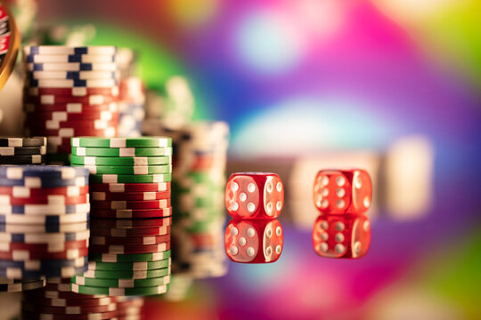 Casino theme.  Gambling games. Roulette, dice and poker chips on a colorful bokeh background.