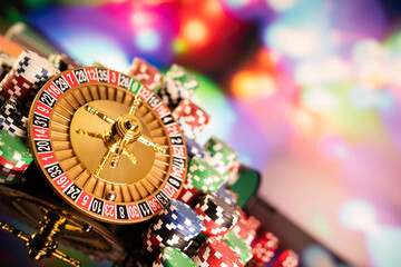 Casino theme.  Gambling games. Roulette, dice and poker chips on a colorful bokeh background.