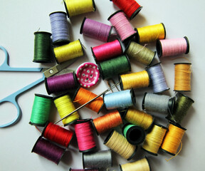 Sewing accessories. Multi-colored threads, needles, scissors, buttons.