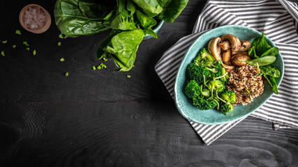 Diet salad made from fresh vegetables broccoli, mushrooms, spinach and quinoa in a bowl. Delicious breakfast or snack, Clean eating, dieting, vegan food concept. vertical image
