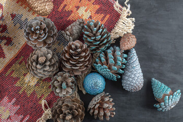 Colorful oak tree cones on a piece of red pattern ethnic rug