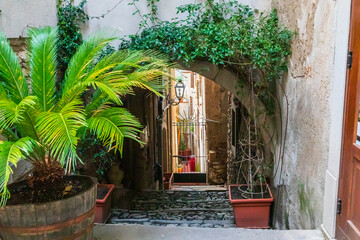 Italy, Sicily, Messina Province, Novara di Sicilia. Arched cobblestone descending walkway of town.