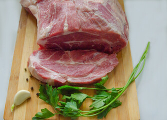 Fresh raw pork steak, isolated on a wooden background. Large piece of fillet of meat close-up