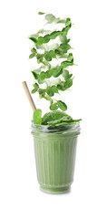 Glass of fresh smoothie and falling spinach leaves on white background