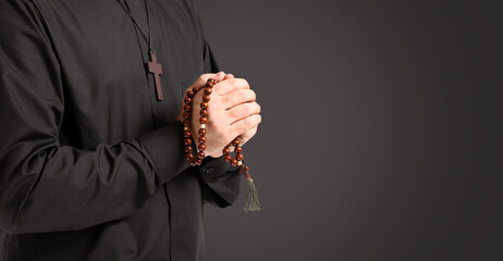 Young priest praying to God on white background, closeup