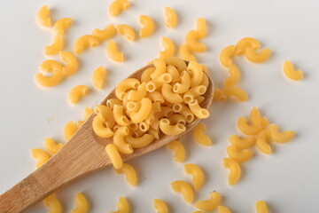 uncooked elbow macaroni on a white background.
