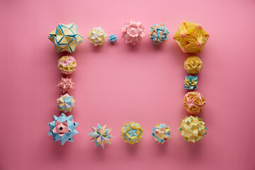 Set of multicolor handmade modular origami balls or Kusudama Isolated on pink background. Visual...