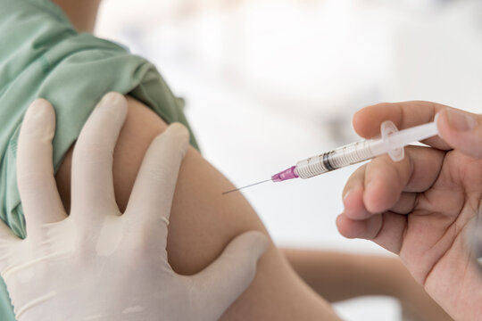 Close up photo of doctor inject vaccine for patient.Selective focus at syringe.Vaccination for corona virus to stop pandemic of covid 19. Drug injection to deltoid muscle for treatment of flu.
