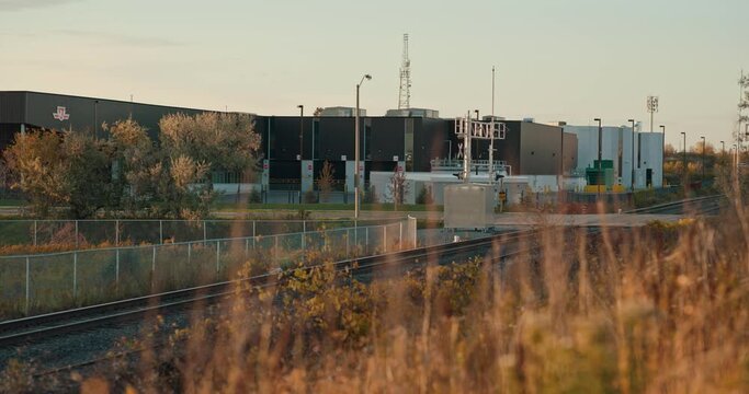 Cars Driving over Train Station Railway Crossing Tracks in Industrial Urban City with Golden Hour Morning Sunrise and Radio Towers in Distance Cinematic Toronto Ontario Markham TTC Cinematic ProRes 4k
