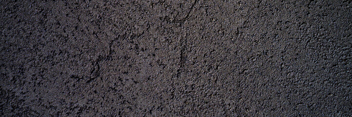 abstract textured dark gray or black surface texture rough background, cement concrete floor or wall. banner