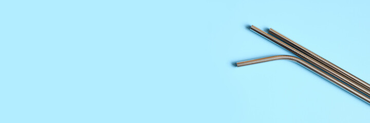 reusable metal stainless steel drinking straws on a blue background. space for text. banner