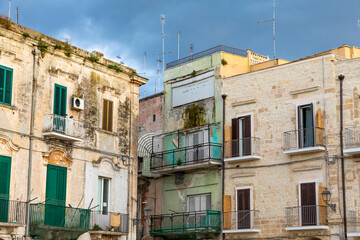 Fototapeta na wymiar Italy, Apulia, Metropolitan City of Bari, Bari. Old buildings with balconies and shuttered windows and TV antennas.