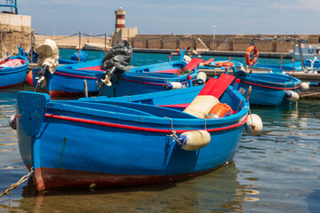 Fototapeta na wymiar Italy, Apulia, Metropolitan City of Bari, Monopoli. Porto di Monopoli. Blue and red fishing boats in the harbor.