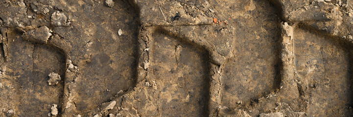 Textured the surface of the earth with a trace of the tread of the wheel as the background, top view. banner