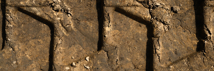 Textured the surface of the earth with a trace of the tread of the wheel as the background, top view. banner
