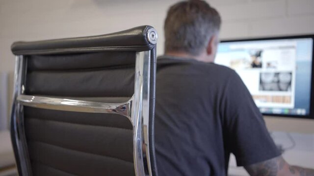 A man sitting at his desk using his comuter
