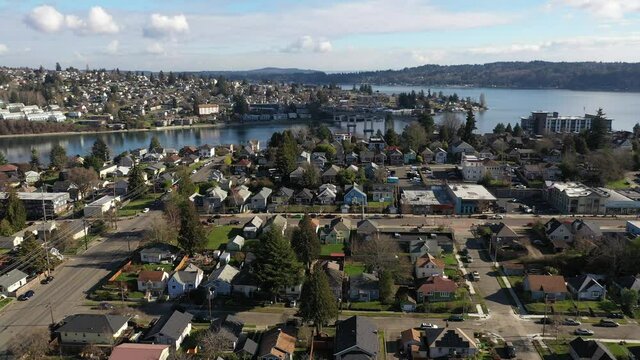 Cinematic aerial drone footage of Bremerton, Manette, Sinclair Inlet, Puget Sound Naval Shipyard, the downtown marina, ferry terminal and shops in the background in Kitsap County, Washington State