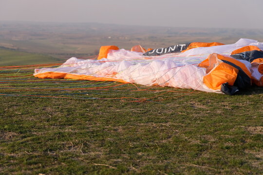 The paraglider is lying on the grass