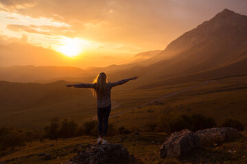 Blonde model at the sunset in mountains 