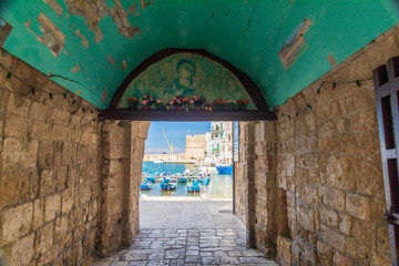 Italy, Apulia, Metropolitan City of Bari, Monopoli. Porto di Monopoli. Arched walkway to the port....