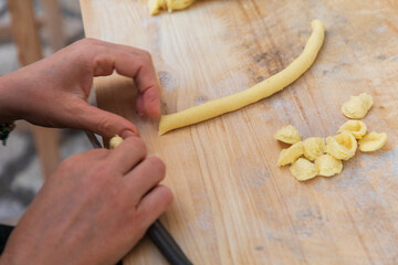 Italy, Apulia, Metropolitan City of Bari, Bari. Woman making fresh conchiglie pasta.