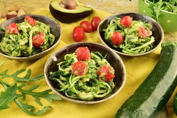 Zucchini noodle with avocado sauce, arugula and cherry tomatoes