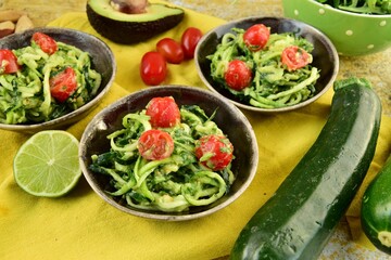 Zucchini noodle with avocado sauce, arugula and cherry tomatoes
