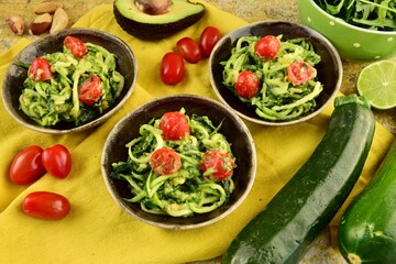 Zucchini noodle with avocado sauce, arugula and cherry tomatoes