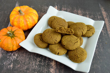 Pumpkin cookies on wooden background with pumpkins on the side