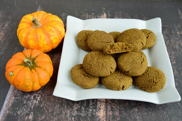 Pumpkin cookies on wooden background with pumpkins on the side