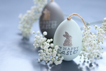 Easter eggs in gentle gray tones and white gypsophila flowers on a gray background.Spring festive...
