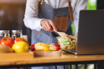 A woman videoblogger cooking in the kitchen and filming, online learning cooking class concept