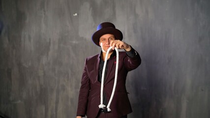 Consummate mastery of magician. The magician shows a trick with a rope.