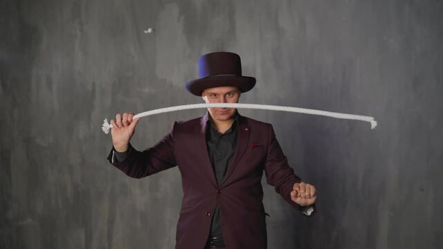 Consummate mastery of magician. The magician shows a trick with a rope.