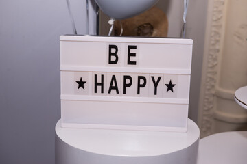 The inscription Be happy in black letters on a white background, symbolizes congratulations and wishes on your birthday and any other holidays.