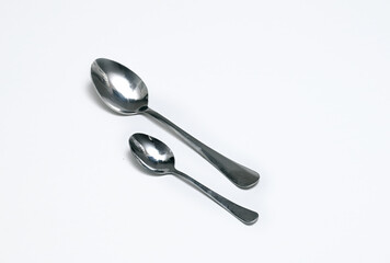 Two spoons on a white background. Image with selective focus.