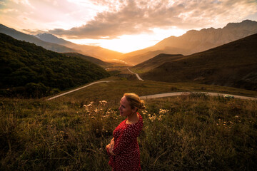 Blonde model at the sunset in mountains 